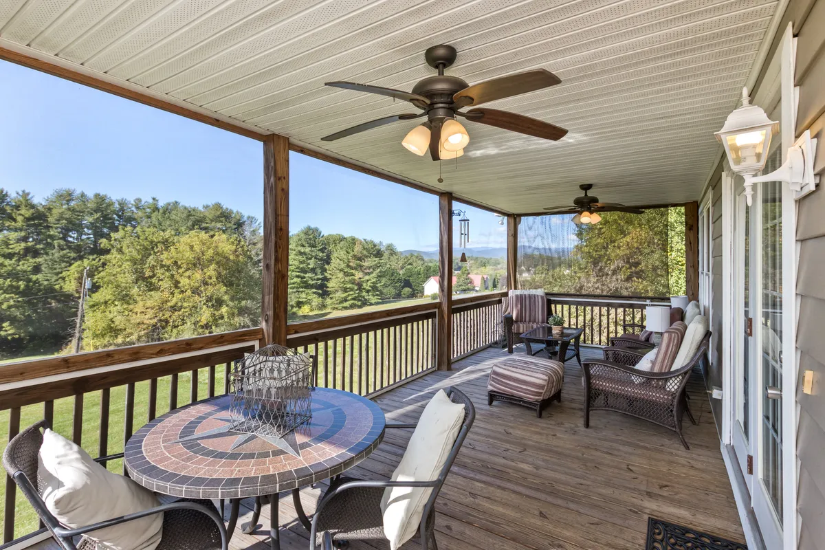 An inviting outdoor seating area with a decorative table set amidst surrounding greenery, all oriented toward a sweeping view of the mountains. The calm, peaceful setting encourages lingering conversations or quiet moments with a book.
