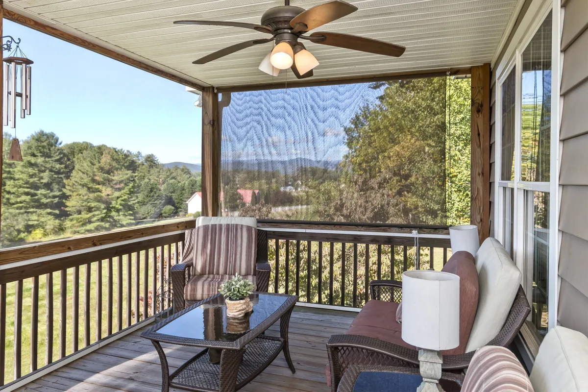 A cozy outdoor seating area with a coffee table set against a panorama of the surrounding landscape, perfect for relaxing after a day in the forest. The arrangement suggests unwinding while enjoying sunset or morning views.